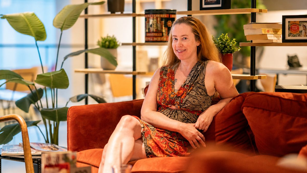 Hanneke Wetzer zit op een oranje bank tijdens het interview bij Douwe Egberts Café in Eindhoven.