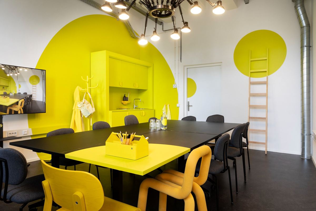 Meeting room with a large table and yellow wall accents